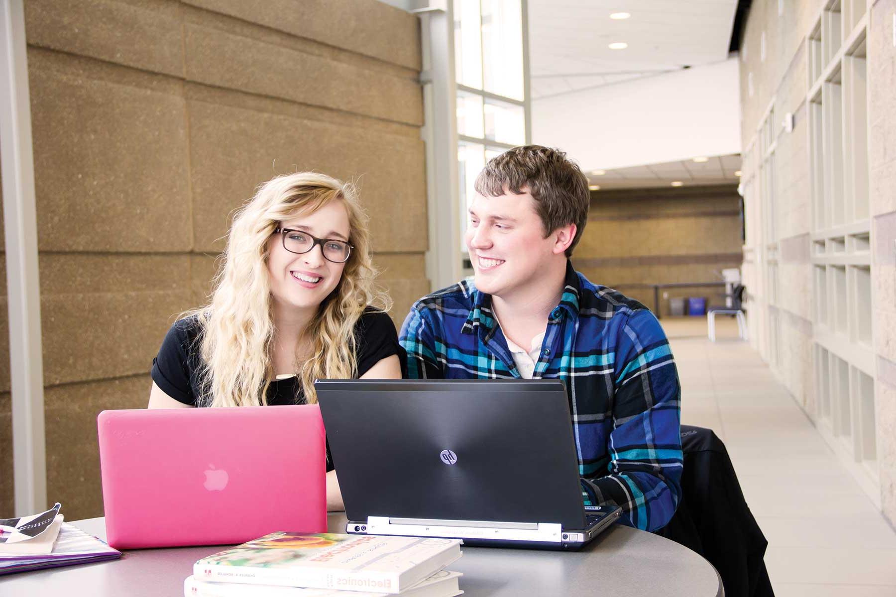 Male and female students with laptops